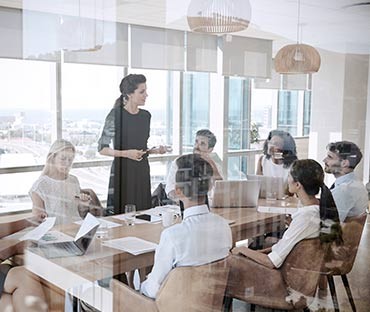business woman leading team meeting around table